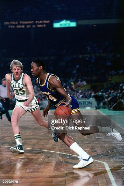 George Johnson of the Indiana Pacers drives against Larry Bird of the Boston Celtics during a game played in 1983 at the Boston Garden in Boston,...