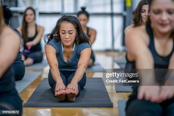stretching in gym - yoga studio stock pictures, royalty-free photos & images