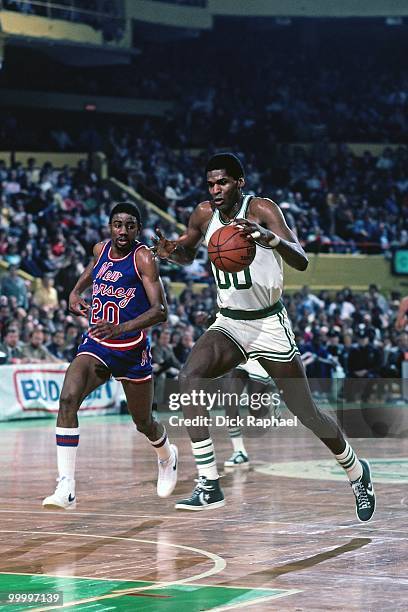 Robert Parish of the Boston Celtics drives to the basket against Micheal Ray Richardson of the New Jersey Nets during a game played in 1983 at the...