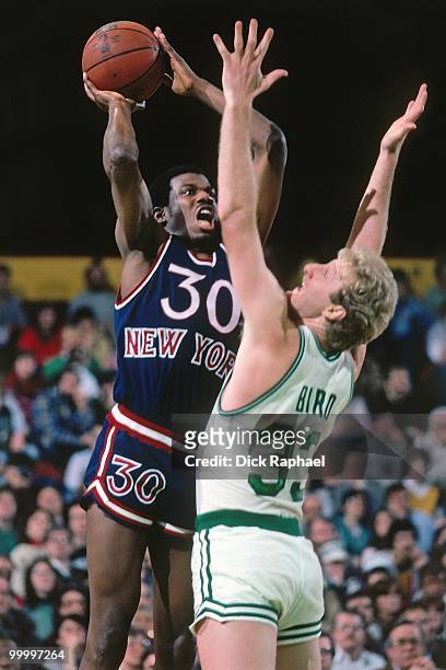 Bernard King of the New York Knicks goes up for a shot against Larry Bird of the Boston Celtics during a game played in 1983 at the Boston Garden in...