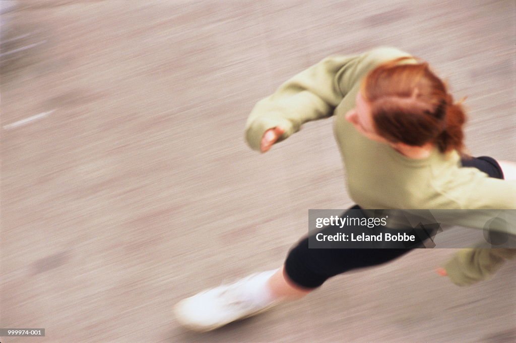 Woman power walking, overhead view (blurred motion)