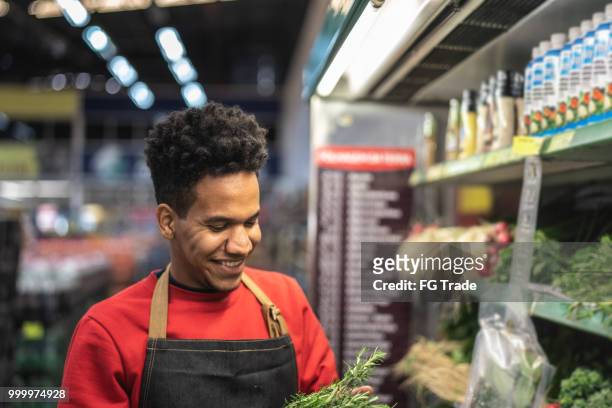 supermarket employee picking some greens - mini grocery store stock pictures, royalty-free photos & images