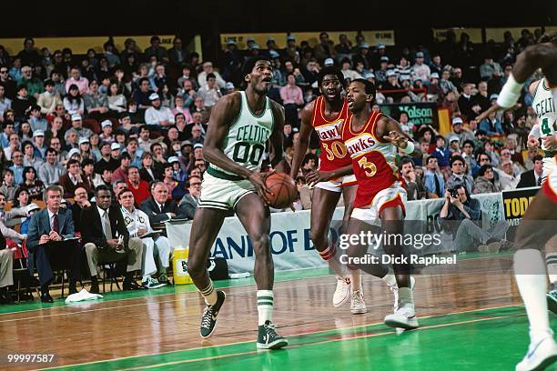 Robert Parish of the Boston Celtics drives to the basket against Eddie Johnson and Tree Rollins of the Atlanta Hawks during a game played in 1983 at...