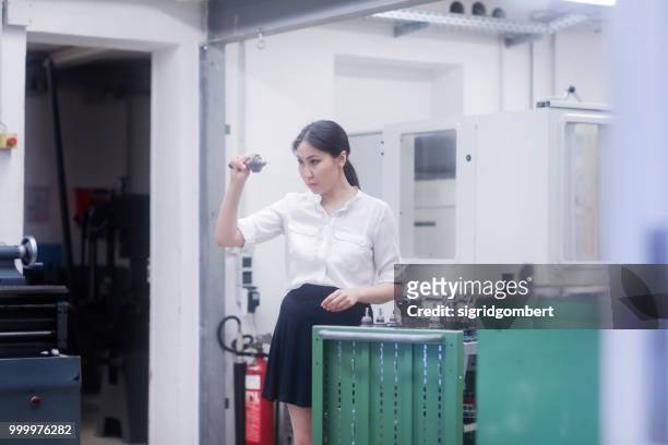 female engineer examining a drill bit - drill bit - fotografias e filmes do acervo