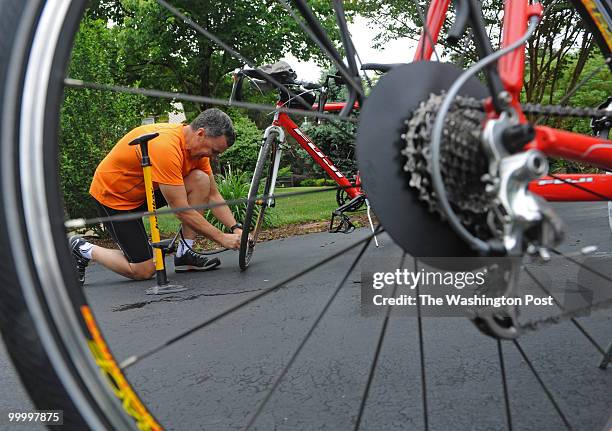 Rob Richer puts air in his tires before loading his bike onto his car on May 18, 2010.