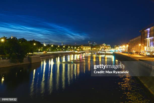 beautiful rare natural phenomenon of noctilucent clouds (night shining clouds) over central part of moscow. a small river in the foreground. shot at long exposure - space and astronomy stock pictures, royalty-free photos & images