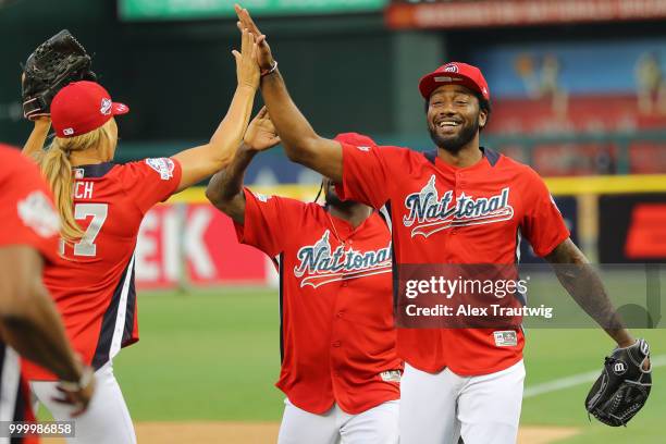 John Wall of the Washington Wizards hi-fives his teammates during the Legends & Celebrity Softball Game at Nationals Park on Sunday, July 15, 2018 in...