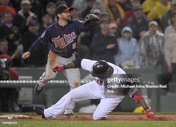 Nick Punto of the Minnesota Twins waits for a throw while David Ortiz of the Boston Red Sox slides safely into third base in the fourth inning on May...