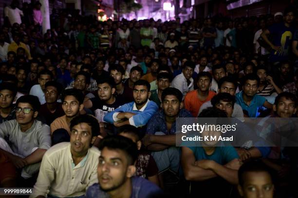 Bangladeshi football lovers watch the Russia 2018 FIFA World Cup football final match between Croatia and France on projector screen at night in...