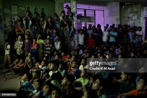 Bangladeshi football lovers watch the Russia 2018 FIFA World Cup football final match between Croatia and France on projector screen at the street in...