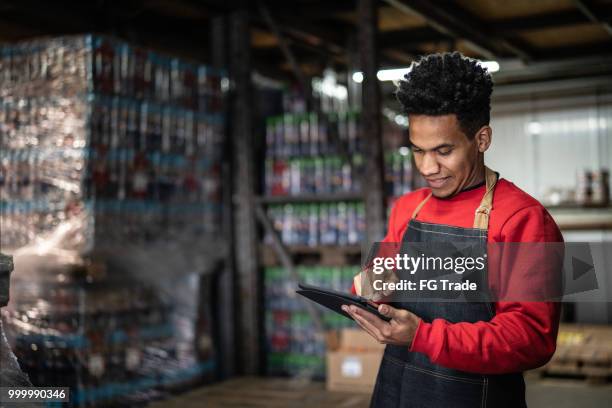 man aan het werk in een magazijn - retail occupation stockfoto's en -beelden