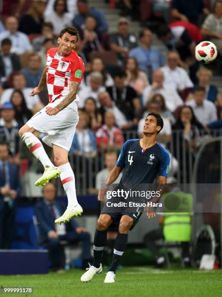 Mario Mandzukic of Croatia and Raphael Varane of France compete for the ball during the 2018 FIFA World Cup Russia Final between France and Croatia...