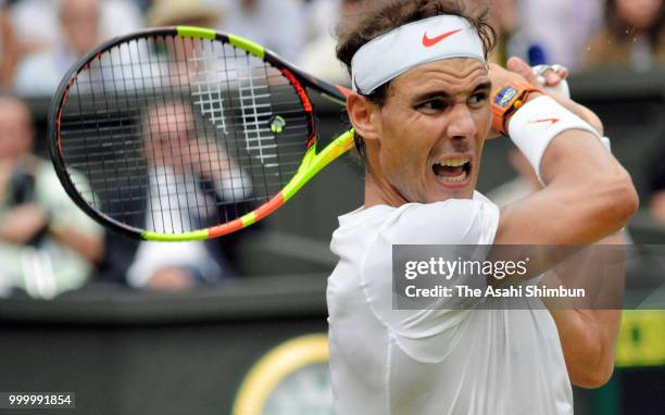 Rafael Nadal of Spain plays a backhand against Novak Djokovic of Serbia during their Men's Singles semi-final on day twelve of the Wimbledon Lawn...