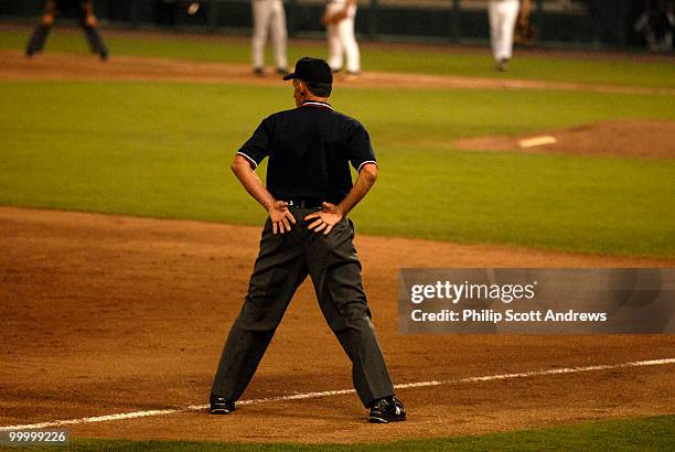 The Third Base Umpire keeps an eye on the game.