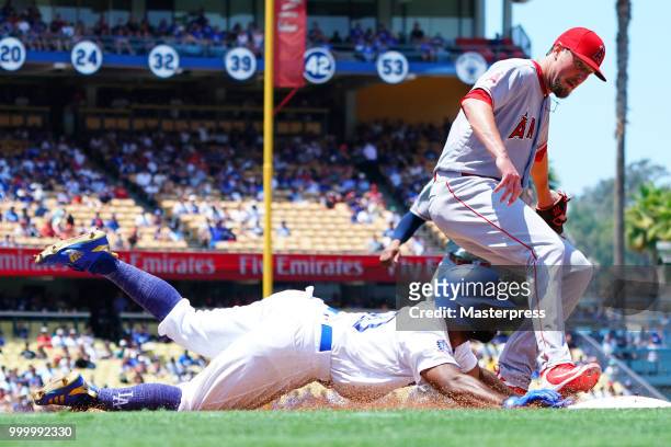 Andrew Toles of the Los Angeles Dodgers dives into first base for a single during the MLB game against the Los Angeles Angels at Dodger Stadium on...