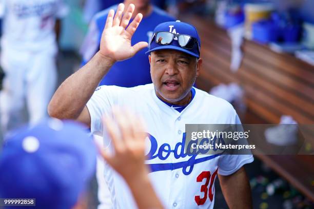 Manager Dave Roberts of the Los Angeles Dodgers high-fives after winning the MLB game against the Los Angeles Angels at Dodger Stadium on July 15,...