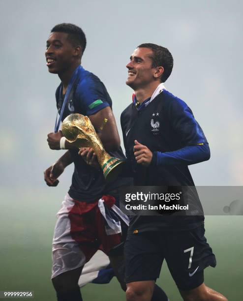Antoine Griezmann of France and Presnel Kimpembe of France are seen with the trophy during the 2018 FIFA World Cup Russia Final between France and...