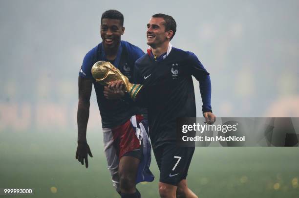 Antoine Griezmann of France and Presnel Kimpembe of France are seen with the trophy during the 2018 FIFA World Cup Russia Final between France and...