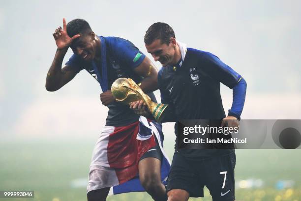 Antoine Griezmann of France and Presnel Kimpembe of France are seen with the trophy during the 2018 FIFA World Cup Russia Final between France and...