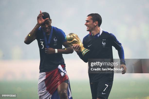 Antoine Griezmann of France and Presnel Kimpembe of France are seen with the trophy during the 2018 FIFA World Cup Russia Final between France and...