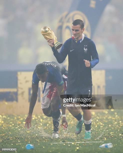 Antoine Griezmann of France and Presnel Kimpembe of France are seen with the trophy during the 2018 FIFA World Cup Russia Final between France and...