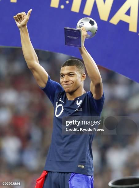 Kylian Mbappe of France raises his trophy after receiving the Young Player award at Luzhniki Stadium in Moscow on July 15, 2018. France beat Croatia...