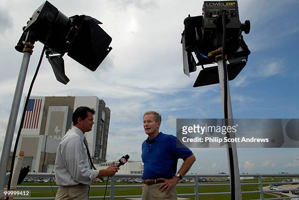 With the Vehicle Assembly Building behind him, Senator Bill Nelson D-Fla, talks to a local television crew on the roof of the Florida Today building...