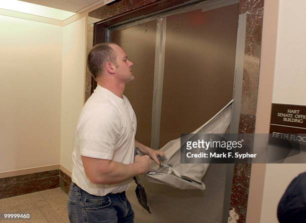 Paul Miklovic tears down the barrier between the fifth floors of the Dirksen and Hart Senate Office Building's on Tuesday morning, in preparation for...