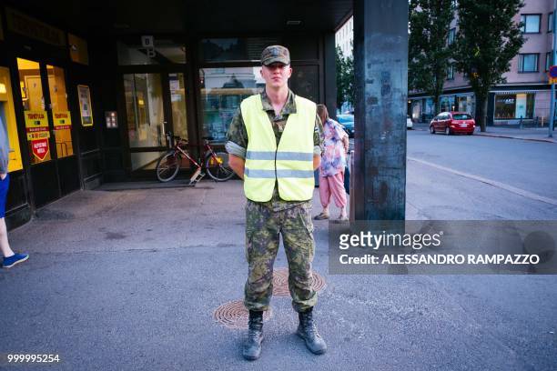 Military stands guard on the Mannerheimintie street, one of the biggest street of Helsinki, Finland on July 15 ahead of the meeting between US...