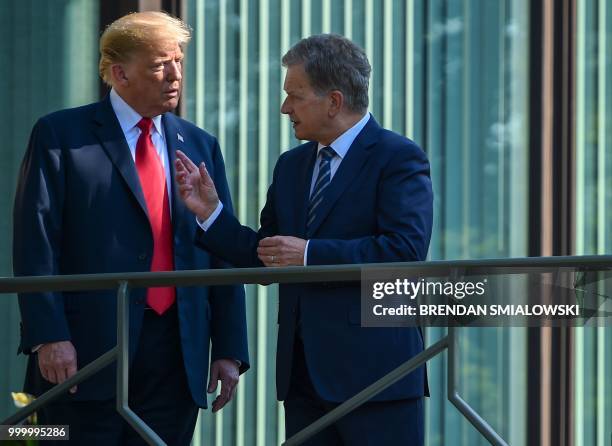 President Donald Trump and Finnish President Sauli Niinisto talk on the balcony of the Mantyniemi Presidential Residence in Helsinki, on July 16,...