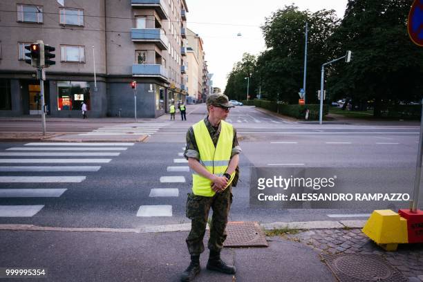 Military stands guard on the Mannerheimintie street, one of the biggest street of Helsinki, Finland on July 15 ahead of the meeting between US...