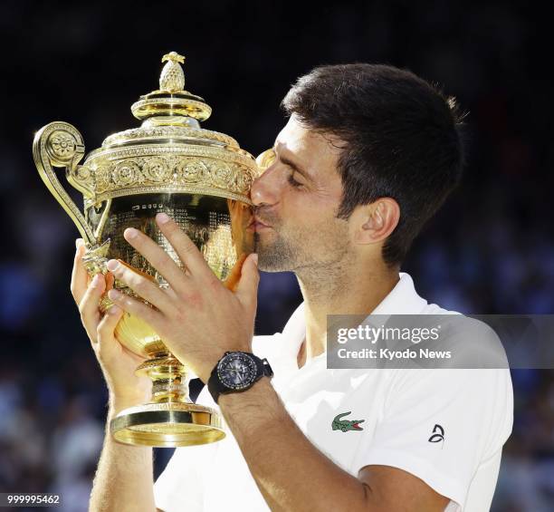 Novak Djokovic of Serbia kisses his trophy after defeating Kevin Anderson of South Africa in the Wimbledon men's singles final in London on July 15,...