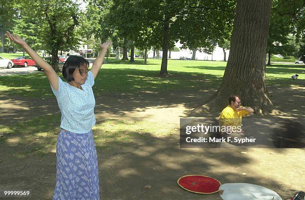 Tiny Tang, of Fairfax, VA. And Robert Nappi, of Alexandria, VA. Practice Falun Dafa on a sweltering Tuesday afternoon on the east lawn of the Capital.