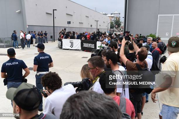 Policemen stand next to medias waiting for Cristiano Ronaldo at the entrance of the Juventus medical center at the Alliance stadium in Turin, on July...
