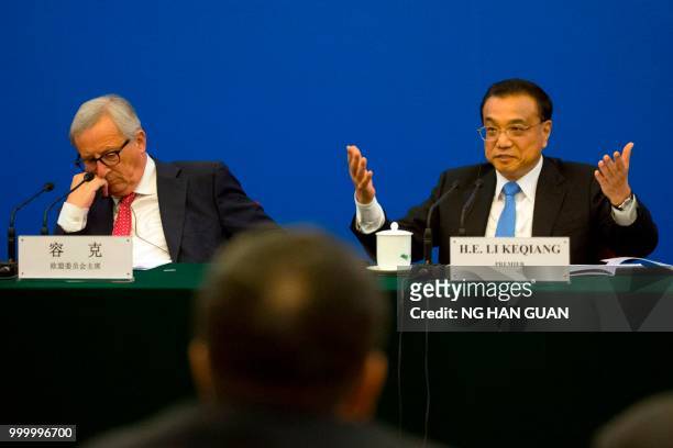 China's Premier Li Keqiang gestures as he calls for action to problems raised by European businessmen, as European Commission President Jean-Claude...