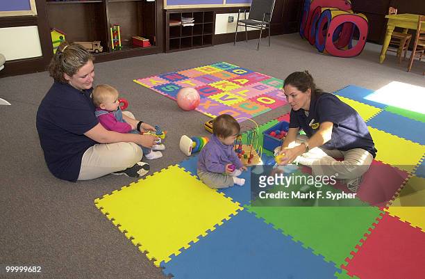 Ruthcarol Touhey and Katie Paun play with youngsters in the daycare center at Results Gym.