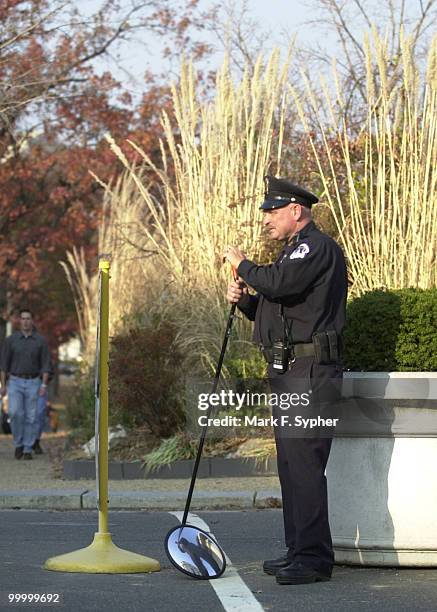 Capitol Police Officer Herbert eyes oncoming delivery trucks at his post behind the Dirksen Building at 1st and C street NE. The mirror he carries is...