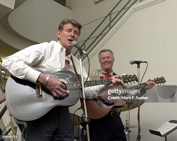 Rep. C.L. "Butch" Otter opens up the collar and rocks the mic with a little help from Rep. Collin C. Peterson .