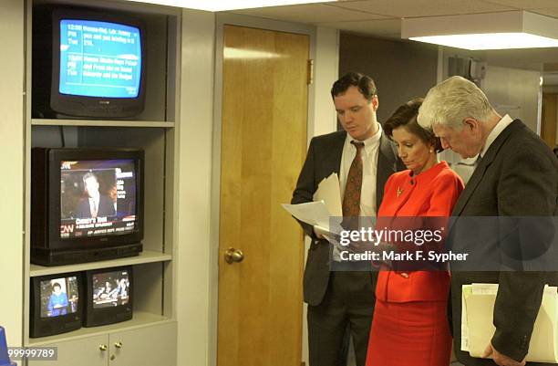 Brendan Daly, left, communication director for Rep. Nancy Pelosi , center, and Rep. James P. Moran go over notes before a news conference on the GOP...