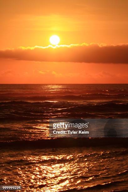 setting sun over crashing waves. - tyler foto e immagini stock