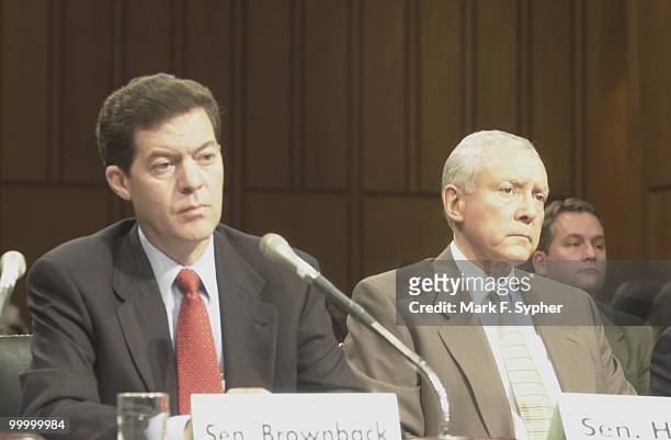 Senators Sam Brownback , left, and Sen. Orrin Hatch listen to Senator Gordon Smith's testamony in support of stem cell research.