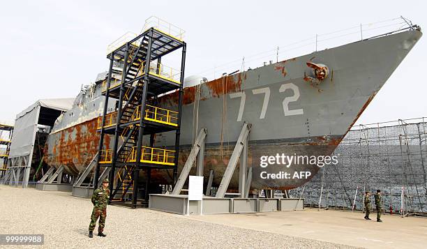 In a picture taken on May 19 South Korean navy personnel stand guard next to the wreckage of the salvaged naval vessel Cheonan, which sank on March...