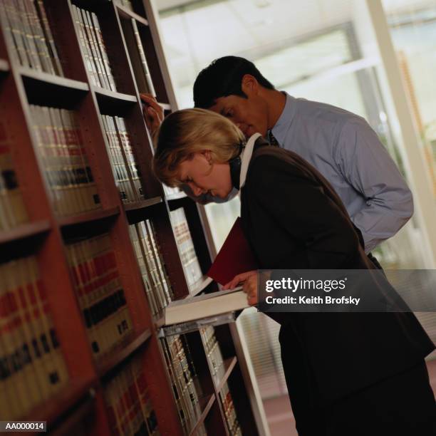 lawyers researching information in a law library - diagonal bookshelf photos et images de collection