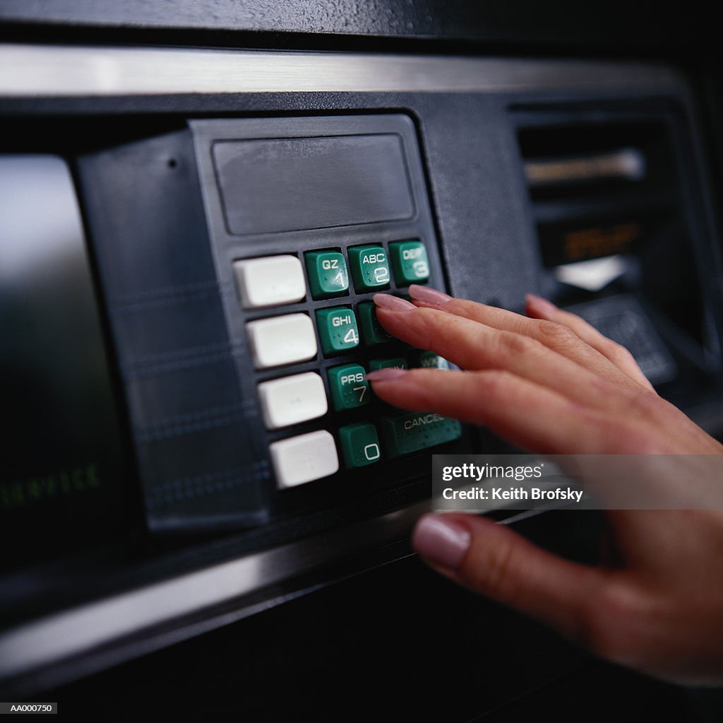 Woman's Hand on a Cash Machine Keypad