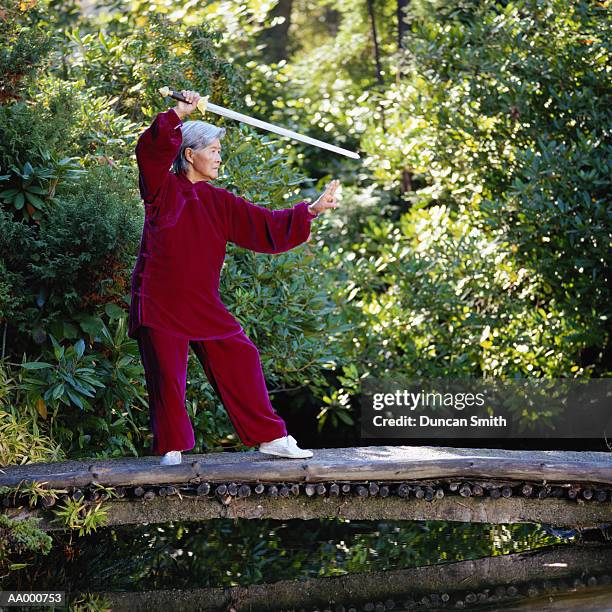 woman doing tai chi chuan with a sword - tai stock pictures, royalty-free photos & images