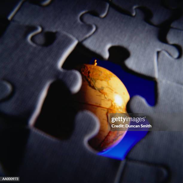 globe seen through a missing puzzle piece - dernière pièce du puzzle photos et images de collection