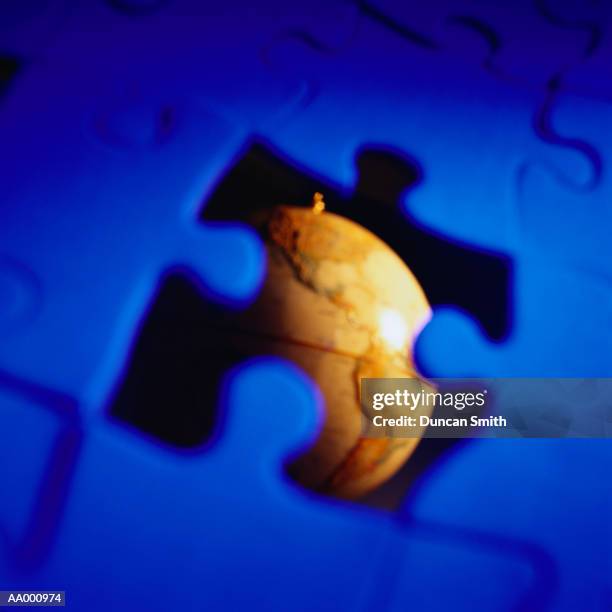 globe seen through a missing puzzle piece - dernière pièce du puzzle photos et images de collection