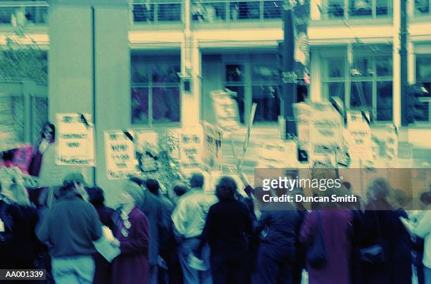 crowd carrying protest signs - picket line stock pictures, royalty-free photos & images