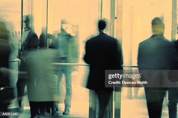 people using a revolving door - revolving door foto e immagini stock