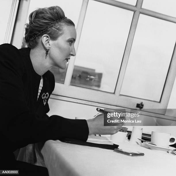 businesswoman reviewing a day planner in a cafe - monica askew stock pictures, royalty-free photos & images